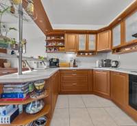 A kitchen in a 4-room apartment with a kitchen unit, open shelves, and modern appliances.