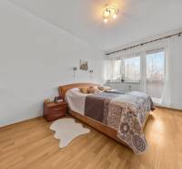 A bedroom with a bed and a wooden decor floor in a 4-room apartment.