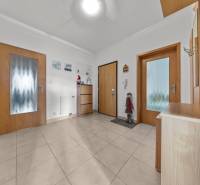 Entrance hall of a 4-room apartment with tiles and wooden doors.