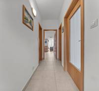 A hallway with tiles and wooden doors in a 4-room apartment.