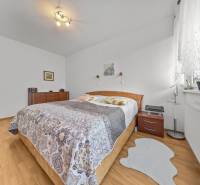 A bedroom in a 4-room apartment with a wood-patterned floor and cozy furnishings.