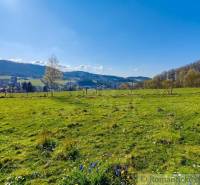 Gardens in Ľubietová with a view of the hills and blue sky.