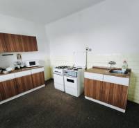 A kitchen with a gas stove, microwave, and cabinets in a family house with wooden decor.