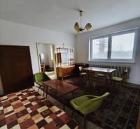 A dining room in a family house with carpets and a ceiling light, floor with wooden decor.