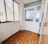 Interior of a family house with a wooden decor floor and glass doors.