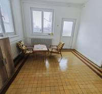 Spacious room with windows, armchairs, and tiles in a family house.