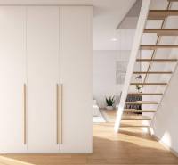 1-room apartment with a staircase, white wardrobe, and wooden decor flooring.