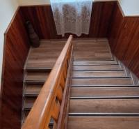 A staircase in a family house with a wooden decor floor and a large window.