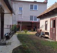The courtyard of a family house in Gemerský Jablonec with a lawn and garden buildings.