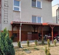 A family house in Gemerský Jablonec with a terrace and a landscaped garden with shrubs.