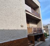 A family house in Gemerský Jablonec with two balconies and a brick cladding.