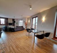 Living room in a two-room apartment with a spacious sofa and a wooden decor floor.