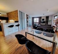 Open space of a 2-room apartment with a kitchen counter and a wooden decor floor.