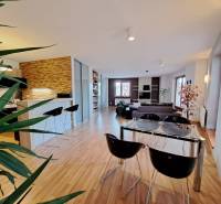 Living room in a two-room apartment with a wooden decor floor and a dining table.