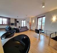 Spacious living area in a 2-room apartment with wood-patterned flooring.