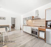 A kitchen in a 3-room apartment with a wooden decor floor and modern equipment.