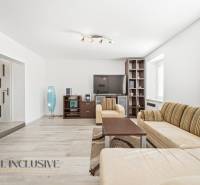 Living room with seating furniture, TV, lamp, and wooden decor flooring in a 3-room apartment.