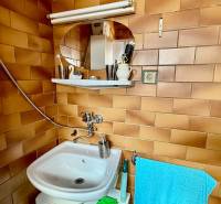 A bathroom in a family house with brown tiles and a white sink.