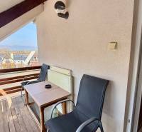 A balcony in a family house with a view of the river, with a table and chairs.