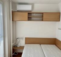Bedroom in a 2-room apartment with a bed, cabinet, and air conditioning.