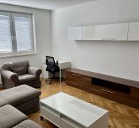 Living room with wood-patterned flooring, sofa, coffee table, and desk.