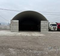 Warehouses and halls in Ladce with trucks parked in front of the arched hall.