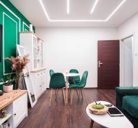 Living room in a 2-room apartment with wooden decor and green accessories.