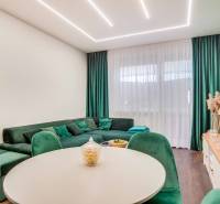 Living room with a comfortable green sofa and a wooden decor floor in a two-room apartment.