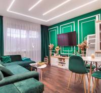Living room in a two-room apartment with a comfortable sofa and a wooden-patterned floor.