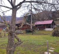 Gardens on Srnkova Street in Banská Bystrica with wooden cottages and trees.