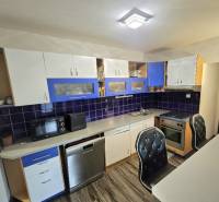 A kitchen in a 3-room apartment with a wooden decor floor and blue details.