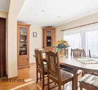 Dining room in a cottage with wooden furniture, a large table, and a bright interior.