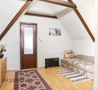 A room with a sofa, carpet, and wooden decor flooring in a cabin.