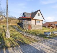 Cottage in Kováčov in Štúrovo with a grassy slope and a stone foundation.