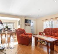 Living room in a cottage with an orange sofa and a fireplace, floor with wood decor.