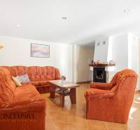 Living room with a sofa and a fireplace in a cabin with a wood-decorated floor.