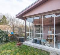 A family house in Šurany with a glass veranda and a garden full of greenery.