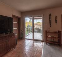 Living room with a large TV and access to the terrace in a family house.