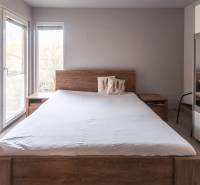 A bedroom with a large bed and a mirrored wardrobe in a family house.