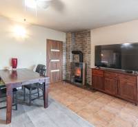 Living room with a fireplace, wooden table, and television in a family house.