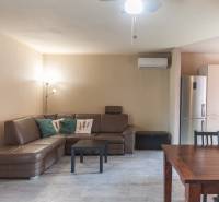 Living room in a family house with a leather sofa and air conditioning, next to the kitchen.