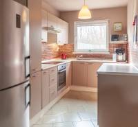 A kitchen unit in a family house with brick cladding and built-in appliances.