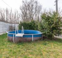 A family house in Šurany with a garden, a swimming pool, and dense vegetation for privacy.