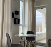 A dining area with a round table and chairs in a 2-room apartment.