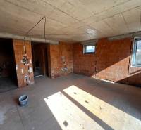 Unfinished interior in a family house with brick walls and exposed installations.