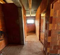 Unfinished interior of a family house with brick walls and simple wiring.