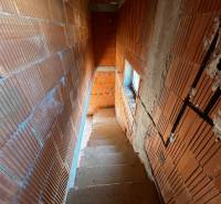 A staircase with brick walls in an unfinished family house.