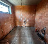 Unplastered brick walls and uncovered flooring in a family house.