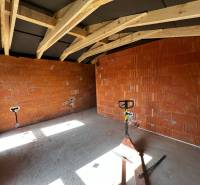 Construction of a family house with brick walls and wooden beams.