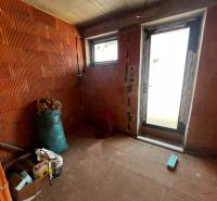 The interior of a family house with brick walls and an entrance door.